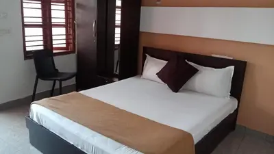 a bedroom with a bed and a chair in it at Tamar padinjarathara in Padinjarathara