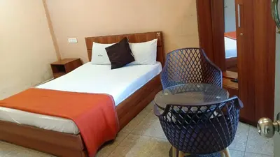 a small bedroom with a bed and a chair at Tamar padinjarathara in Padinjarathara