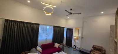 a living room with a couch and a ceiling fan at SARA'S LUXURY stay in Coimbatore (Peelamedu)