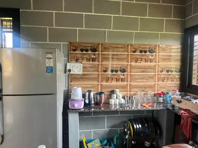 a kitchen with a refrigerator and a counter with cups at Cozy Tiny Farm Stay in Mysore