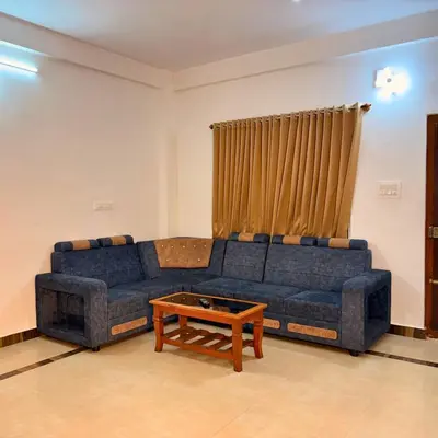 a living room with a blue couch and a coffee table at Unnati Luxury Homestay Coorg in Madikeri