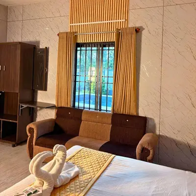 a living room with a couch and a bed at Unnati Luxury Homestay Coorg in Madikeri