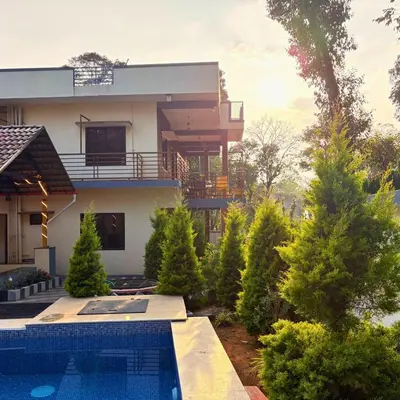 a house with a swimming pool in front of it at Unnati Luxury Homestay Coorg in Madikeri