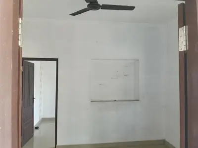 a ceiling fan in a room with a mirror at Property near cochin international airport in Alwaye