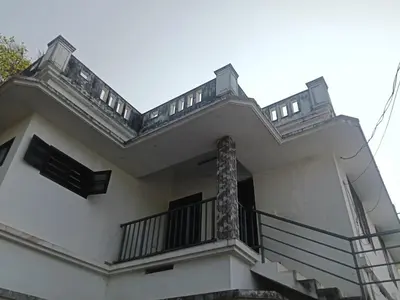a white house with a balcony and stairs at Property near cochin international airport in Alwaye