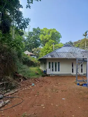 a white house with a dirt road in front of it at Apple Valley in Munnar