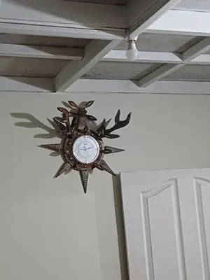 a clock hanging on a wall next to a door at Apple Valley in Munnar