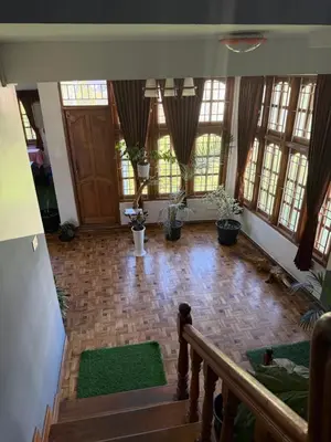 a large room with a staircase and windows at DM&sons guesthouse in Coonoor