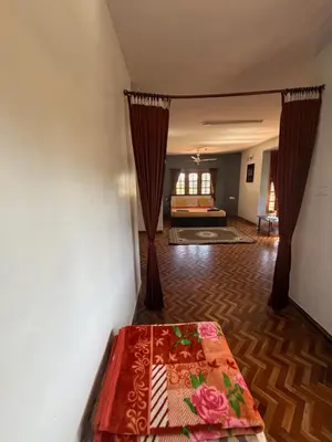 a living room with a bed and a bedroom at DM&sons guesthouse in Coonoor