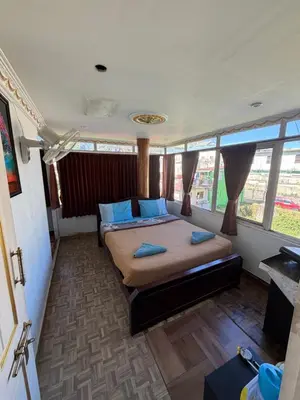 a bedroom with a bed with blue pillows in it at DM&sons guesthouse in Coonoor