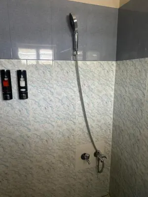 a shower in a bathroom with a shower head at Grace villa in Kunnamkulam