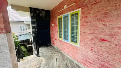 a red building with a window on the side of it at Grace villa in Kunnamkulam