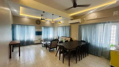 a living room with a table and a dining room at Grace villa in Kunnamkulam