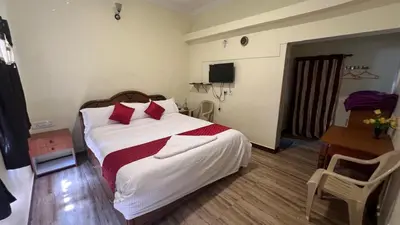 a bedroom with a large white bed with red pillows at Bull Bull Homestay in Ooty