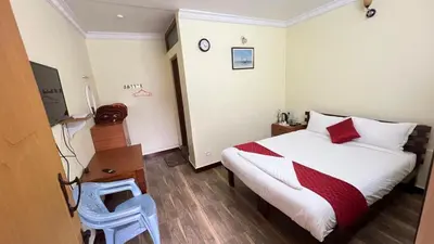 a bedroom with a bed with a red and white blanket at Bull Bull Homestay in Ooty