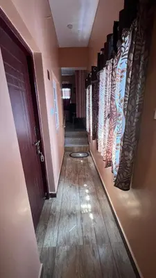 a hallway with a row of doors and a wooden floor at Bull Bull Homestay in Ooty