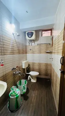 a bathroom with a toilet and a sink at Bull Bull Homestay in Ooty
