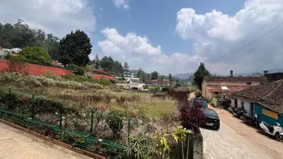 a small town with cars parked on a street at Bull Bull Homestay in Ooty