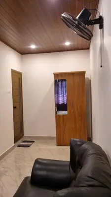 a room with a leather chair and a wooden door at Hotel Arena in Mahe