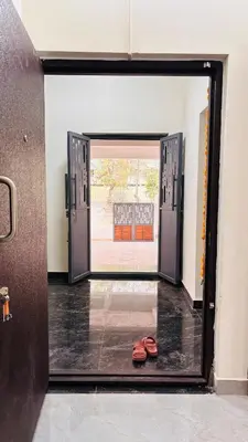 an open door with a pair of shoes in a room at Ashley Homestay 2BHK Codissia, Airport, Tidel Park in Coimbatore
