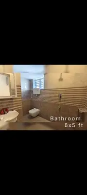 a bathroom with two sinks and a toilet in a room at R N P Guest House in Pollāchi