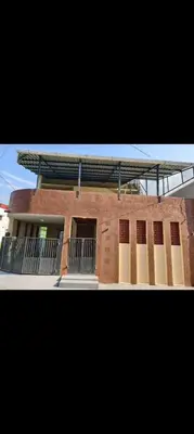 a red brick building with windows and a balcony at R N P Guest House in Pollāchi