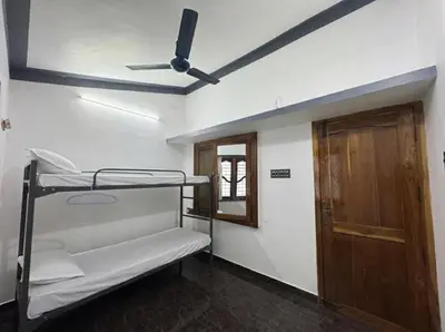 a room with two bunk beds and a ceiling fan at Sreekrishnapuram Family Retreat in Karimpuzha