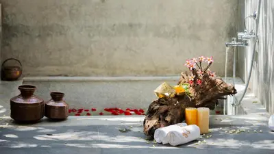 a bathroom with a bath tub with flowers and candles at SaffronStays Chandra Amara in Bengaluru