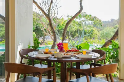 a table with food and drinks on a balcony at SaffronStays Chandra Amara in Bengaluru