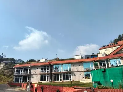 an old brick building with a red roof at TULIPS VILLAGE RESORTS - A Valley View Abode in Ooty
