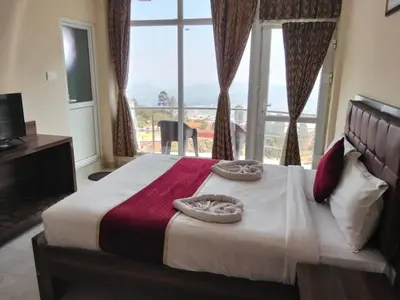a bedroom with a large bed with a large window at TULIPS VILLAGE RESORTS - A Valley View Abode in Ooty