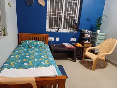 a bedroom with a bed and a table and a chair at K square in Coimbatore
