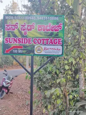 a sign for a sunrise coffee on the side of a road at Sun Side Cottages in Madikeri