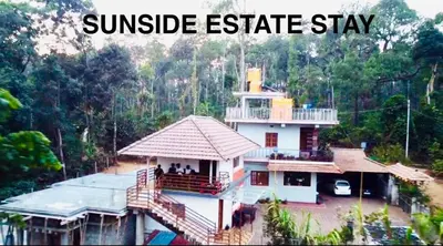 a house in the middle of a jungle with the words sunrise estate stay at Sun Side Cottages in Madikeri