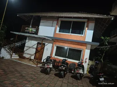 a group of motorcycles parked outside of a house at night at Sun Side Cottages in Madikeri