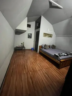 a bedroom with a bed and a wooden floor at spiritofthewild in Attappādi