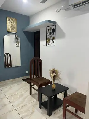a living room with two chairs and a table at Nandbhavan Guruvayur in Guruvāyūr