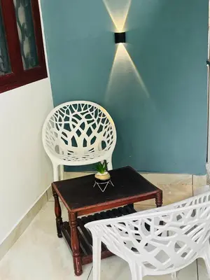 a white chair and a table in a room at Nandbhavan Guruvayur in Guruvāyūr