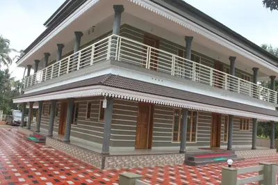 a building with a balcony on the side of it at SHANKARAM Homestay in Kodanad