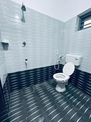 a bathroom with a white toilet in a room at VYSHNAVI 2BHK AC Apartment in Thanniyam