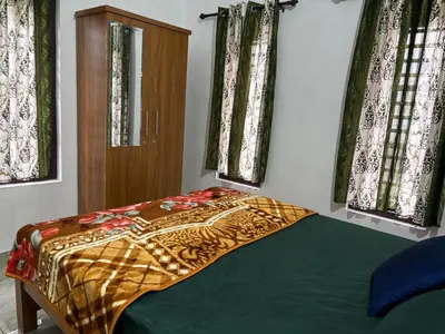 a bedroom with a bed with a blanket on it at Nilavu Homes Retreat in Wayanad