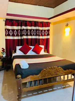 a bedroom with a large bed with red curtains at Coorgkushihomestay in Madikeri
