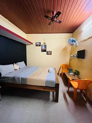 a bedroom with a bed and a ceiling fan at Coorgkushihomestay in Madikeri