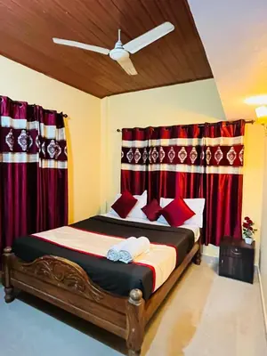 a bedroom with a bed with red curtains at Coorgkushihomestay in Madikeri