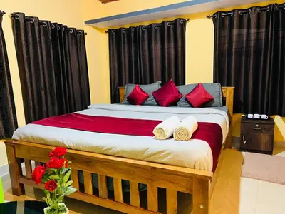a bedroom with a large bed with red pillows at Coorgkushihomestay in Madikeri