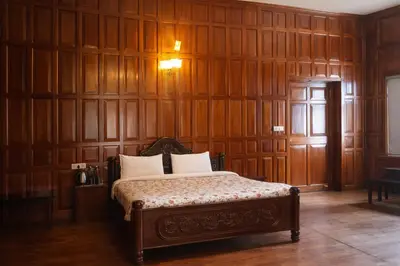 a bedroom with a bed with wood paneled walls at Mount View Heritage by Z Vacations in Ooty