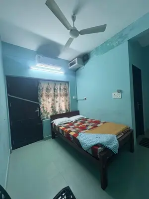 a bedroom with a bed and a ceiling fan at GK residency in Kozhikode
