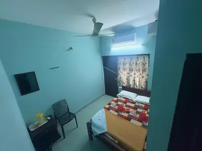 a room with a bed and a chair in it at GK residency in Kozhikode