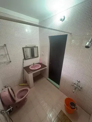 a bathroom with a pink toilet and a sink at GK residency in Kozhikode