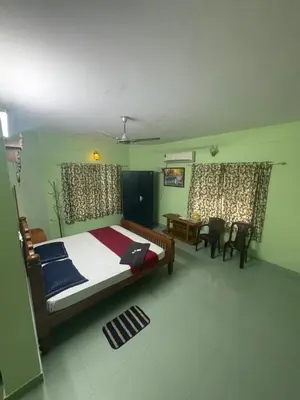 a bedroom with a bed and a table and chairs at GK residency in Kozhikode